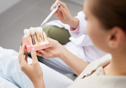 Medicul specialist în implantologie la City Dent explicand cum arata un implant dentar