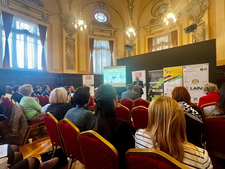 Conferința „Viitorul afacerilor de familie în România” desfășurată la Palatul Camerei de Comerț și Industrie București, unde participanții asistă la o prezentare despre digitalizare și inovație în afaceri. În prim-plan, un speaker susține un discurs în fața unui ecran proiectat, cu bannere ale organizatorilor și partenerilor în fundal.