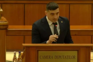 George Simion adresându-se Parlamentului din România, exprimându-și nemulțumirea față de conducerea guvernamentală, în timp ce stă la pupitrul Camerei Deputaților.