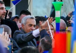 Călin Georgescu înconjurat de susținători în timpul unei manifestații pentru democrație, reflectând spiritul unității și dorința de schimbare în România.