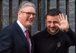 Premierul britanic Keir Starmer alături de președintele ucrainean Volodimir Zelenski, zâmbind și salutând, în timpul unei întâlniri la Londra