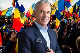 Călin Georgescu înconjurat de o mulțime de susținători agitând steaguri românești și europene, în timpul unui protest, zâmbind încrezător spre cameră.