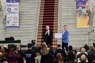 Reprezentantul ICI București primește diploma de recunoaștere din partea InfoCons pe scena principală a unui eveniment oficial dedicat Zilei Mondiale a Proprietății Intelectuale, desfășurat la Palatul Parlamentului, în fața unei audiențe formate din oficiali, presă și participanți.