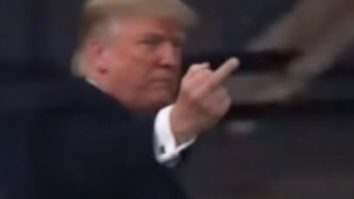 Trump, filmat arătând degetul, într-o vizită la o fabrică Ford, la Detroit. Casa Albă consideră că a dat un răspuns ”adecvat şi lipsit de ambiguitate”. Destinatarul gestului urla ”protectorul pedofilului”, dezvăluie TMZ