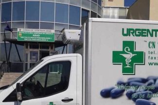 Autoutilitară CN Unifarm SA utilizată pentru livrări de medicamente de urgență, parcată în fața unei unități spitalicești din România.