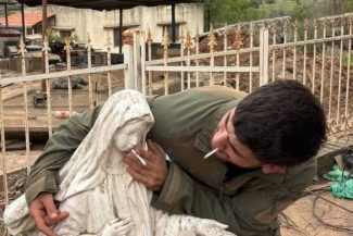Un soldat israelian apropie o țigară de gura unei statui a Fecioarei Maria din Liban