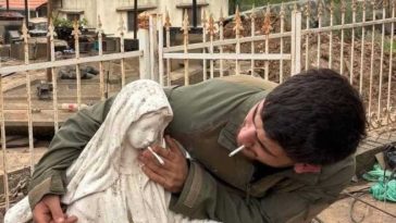 Un soldat israelian apropie o țigară de gura unei statui a Fecioarei Maria din Liban