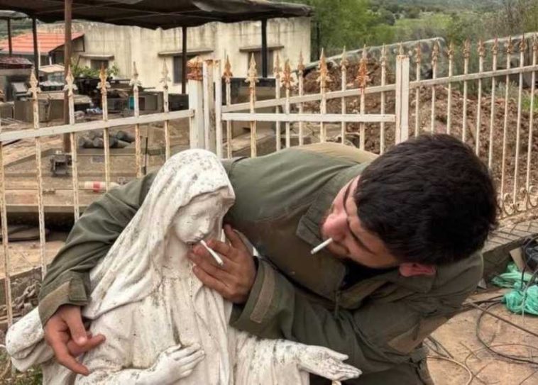 Un soldat israelian apropie o țigară de gura unei statui a Fecioarei Maria din Liban