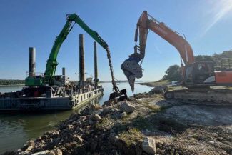 ANAR: Acțiunile de dragaj pe Dunărea Veche continuă; două excavatoare sparg mecanizat piatră pentru încărcarea barjelor
